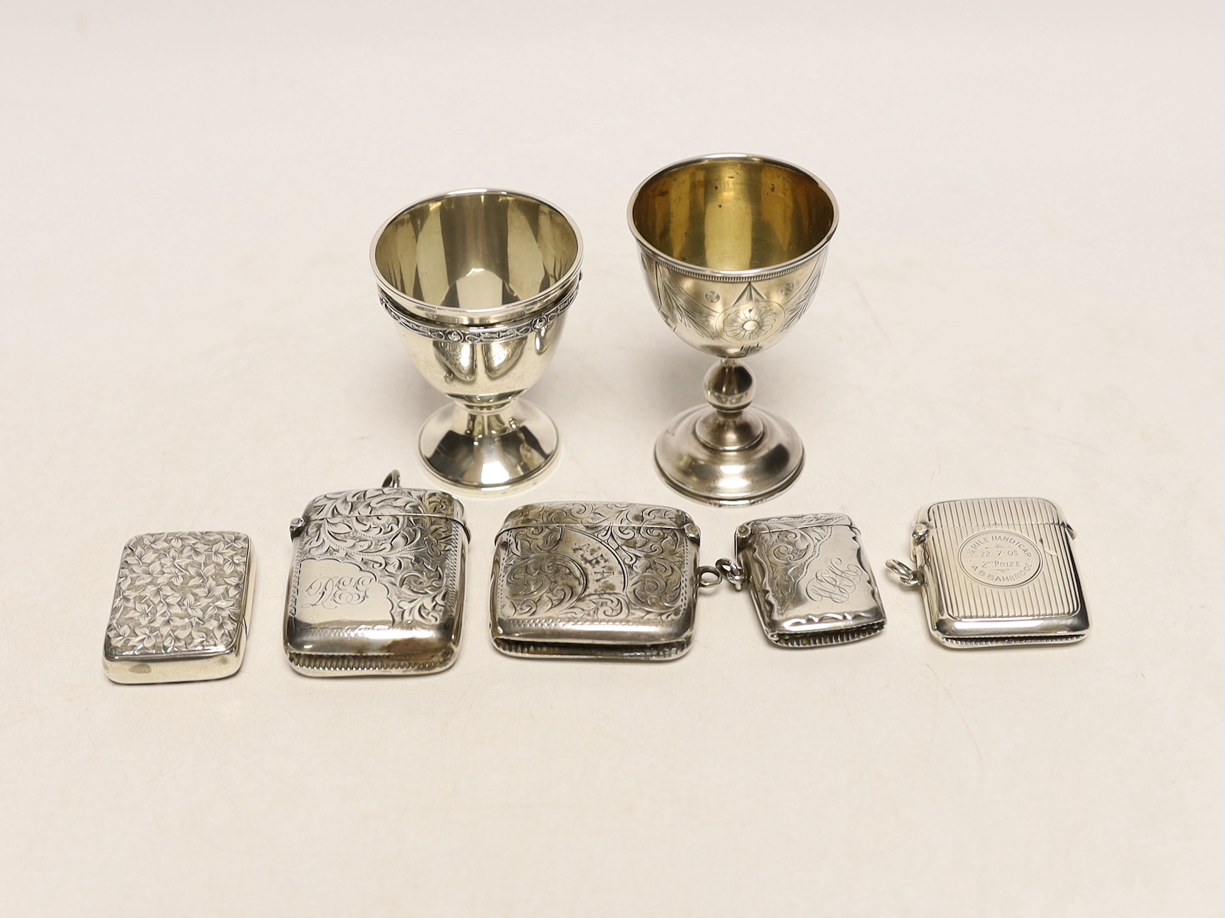 An early 20th century Russian 84 zolotnik egg cup, 69mm a later silver egg cup and five assorted silver vesta cases.